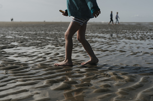 Detailed picture of a child wandering through the mudflats