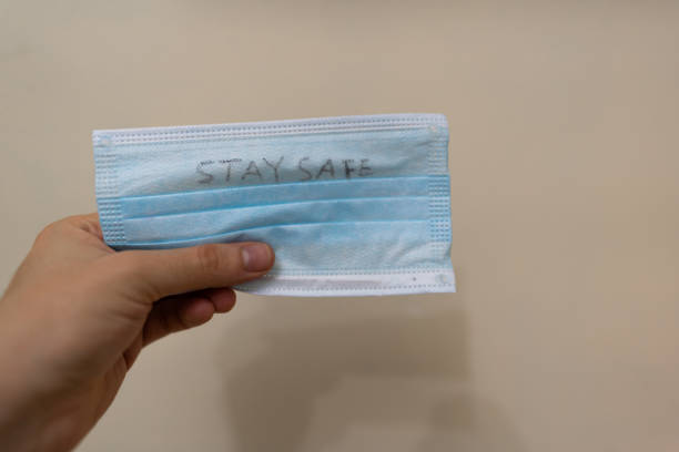 istock Face mask with a personal handwritten message 'stay safe' | virus protection 1225595849