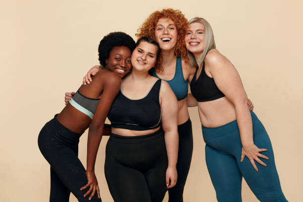 Different Race. Diversity Figure And Size Models Portrait. Smiling Multicultural Women In Sportswear Posing On Beige Background. Body Positive As Lifestyle.