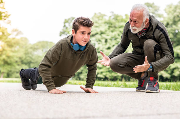 istock Grandfather telling his son how to do a good push-up 1225597907