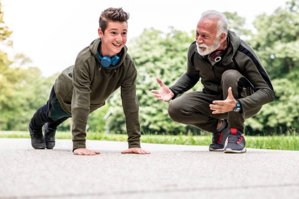 istock Grandfather telling his son how to do a good push-up 1225597934