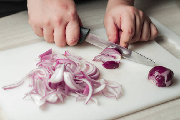 istock woman cutting fresh white onion with knife 1225598446