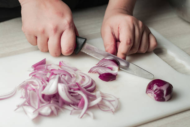 istock woman cutting fresh white onion with knife 1225598472