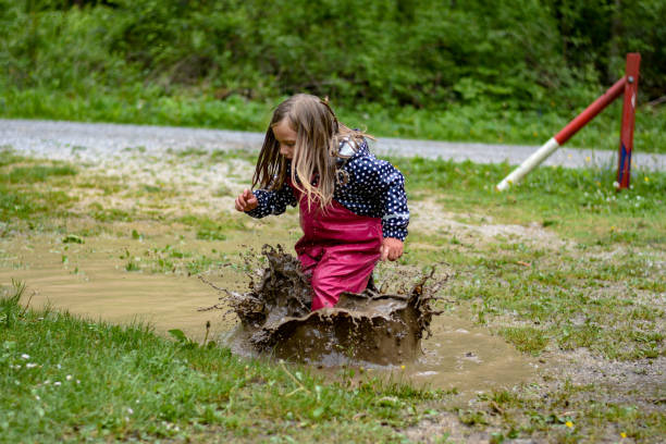 istock The girl is playing in a mud puddle and splashing 1225600356