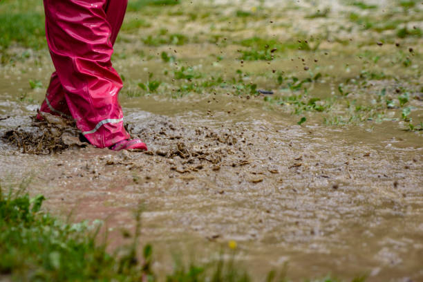 istock The girl is playing in a mud puddle and splashing 1225600361