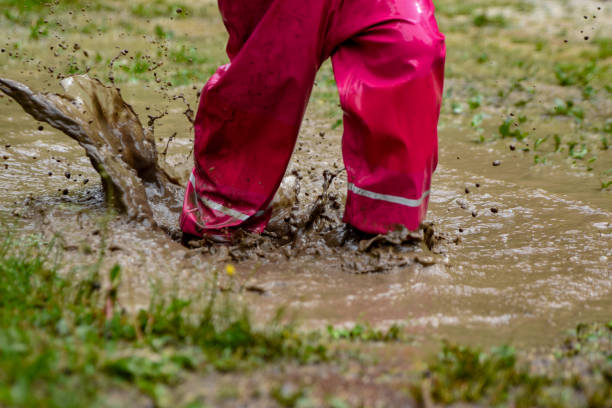 istock The girl is playing in a mud puddle and splashing 1225600364