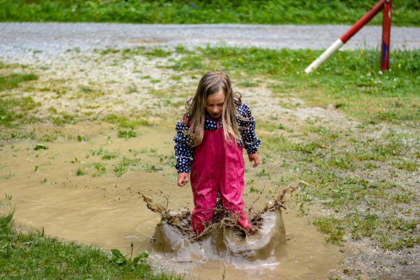 istock The girl is playing in a mud puddle and splashing 1225600370