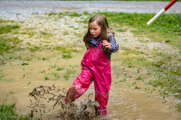 istock The girl is playing in a mud puddle and splashing 1225600373