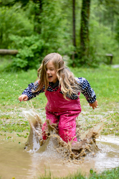 istock The girl is playing in a mud puddle and splashing 1225600382