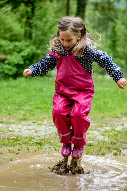 istock The girl is playing in a mud puddle and splashing 1225600383