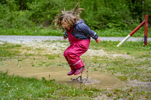 istock The girl is playing in a mud puddle and splashing 1225600385