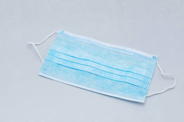 istock Blue medical mask on a gray background 1225601745