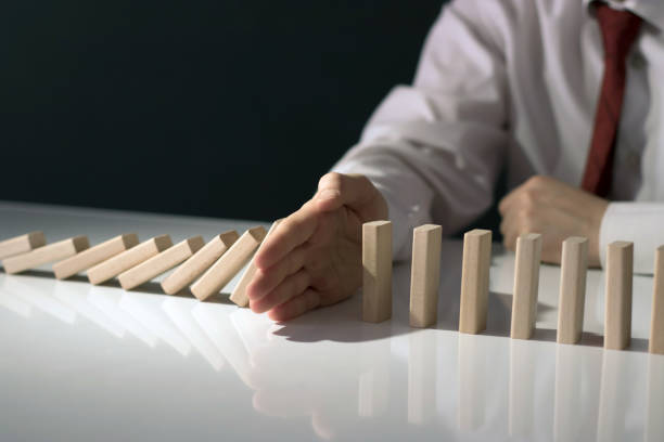 istock Businessman Stop Domino Effect. Risk Management and Insurance Concept 1225601901