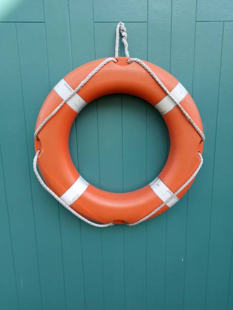 istock Red Lifesaver Ring for Boat on Green Wall Close up 1225608887