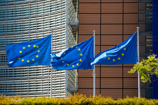 BRUSSELS, Belgium - fourth of may 2020 :  flags waving in the wind in front of the Berlaymont building, the headquarters of the European Commission.