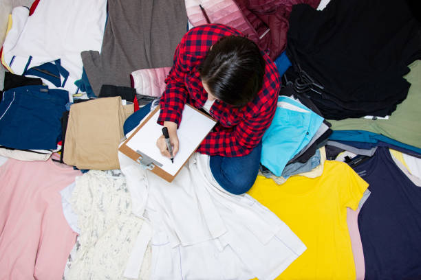 Messy closet filled with different used unfresh clothes, sloppily shoved,hanging from shelves. Fast fashion. Pile of dirty cluttered woman's wardrobe stuffed in available space,need for declutter.