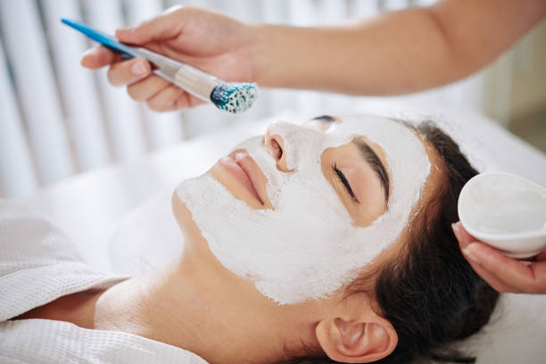 istock Cosmetologist applying clay mask 1225624776