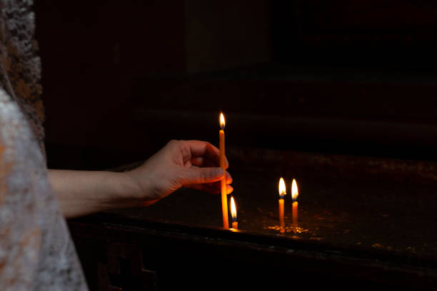 istock woman light a candle in church 1225627792