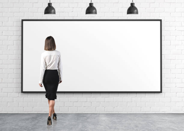 istock Businesswoman looking at empty whiteboard 1225628336
