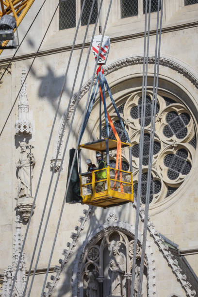 Workers with tall cranes fixing Zagreb Cathedral tower Zagreb, Croatia - April 15, 2020 : Workers with tall cranes are preparing to separate top of the Zagreb Cathedral tower that was damaged by the earthquake of 5.5 on the Richter scale one month ago. zagreb earthquake stock pictures, royalty-free photos & images