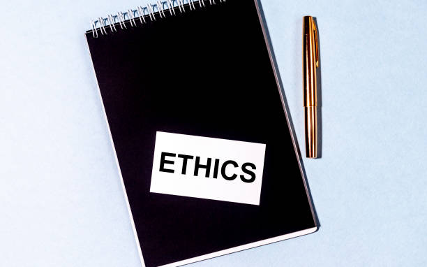 istock Ethics word text inscription written on a white paper card on a black notebook with golden pen on blue background. Top view flatlay. Ethics concept 1225629235