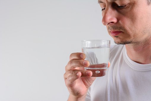 close up portrait of handsome man drinking a glass of water