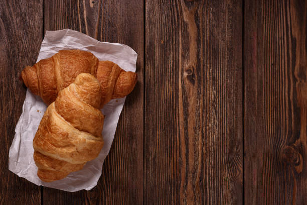 istock Tasty croissants on dark wooden table. 1225630290