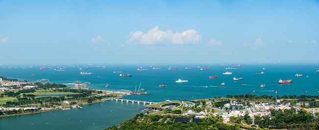 Panorama view of Singapore City skyline and business logistic sea going ship, Crude Oil tanker, Cargo ships entering of the busiest ports of Singapore harbor.