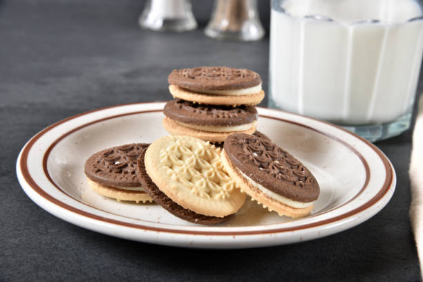 istock A stack of chocolate and vanilla cream sandwich cookies with milk 1225631915
