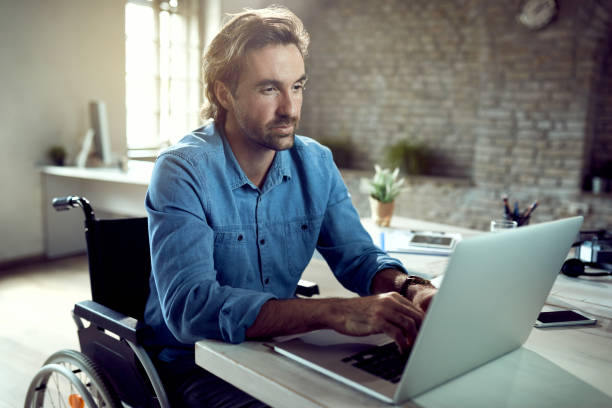 istock Young disabled businessman working on laptop in the office. 1225632806