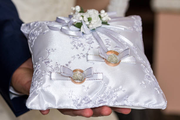 istock The groom holds a white pillow with wedding rings 1225633630