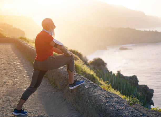 istock Senior fit man stretching outdoor at sunset before workout session - Mature athlete training outside while listening playlist music - Sport and joyful elderly lifestyle concept 1225636285