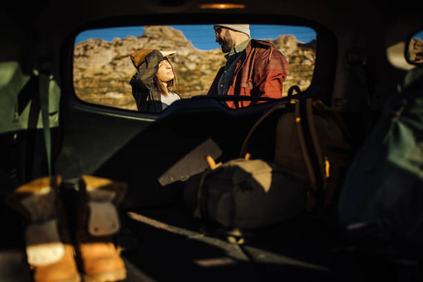 istock Couple taking backpack out of car trunk in nature 1225638486