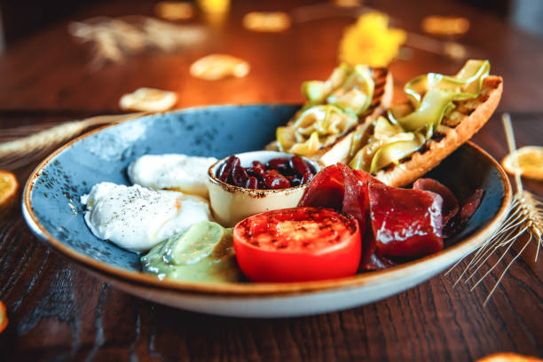 istock Appetizing breakfast with squash toasts, beans, poached eggs, meat and vegetables 1225638994