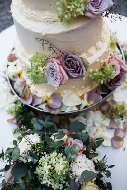 istock Wedding cake standing on the table. Around the flowers. 1225640462