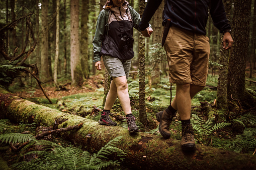 Young couple of hiker walking in forest with backpacks on their adventure