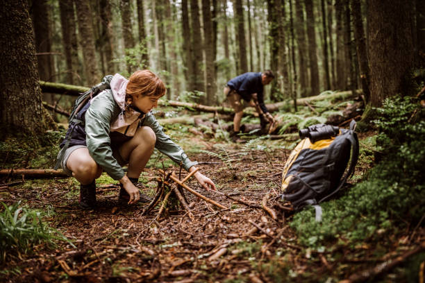istock Couple making campfire in woodland 1225646153