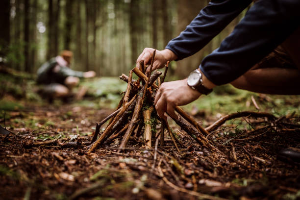 istock Couple making campfire in woodland 1225646159