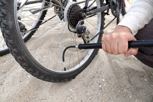 istock Men's hands pump up a bicycle wheel close-up 1225646264