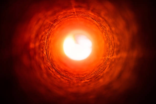 istock Looking through a cardboard tube towards a bright.defocused multi-coloured light 1225651546