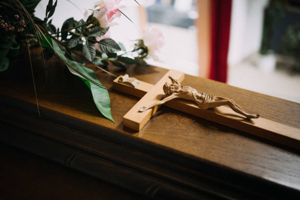 photo of a cross on a wooden casket photo of a cross on a wooden casket at a funeral funeral parlor photos stock pictures, royalty-free photos & images