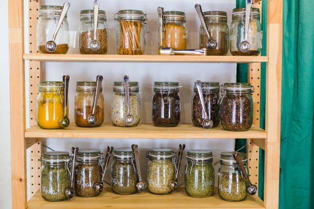 Shelves with a selection of spices and grains in glass jars in zero waste shop stock photo
