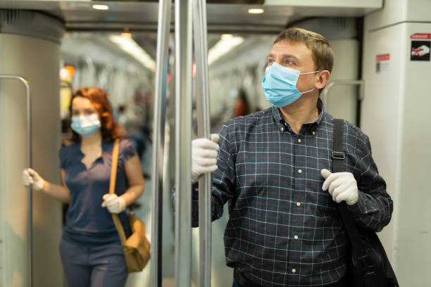 istock Man in medical mask riding in subway car 1225655938