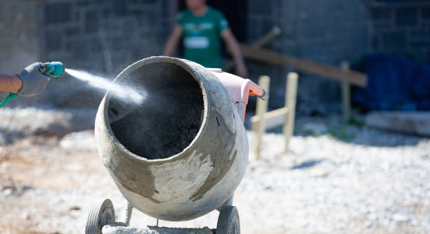 istock Concrete mixer being manually filled with cement and sand and water on an active building site 1225659543