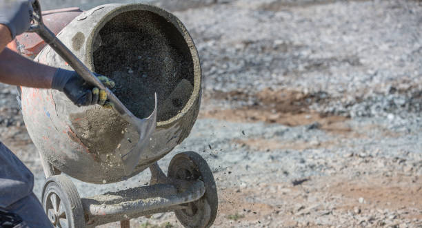 istock Concrete mixer being manually filled with cement and sand and water on an active building site 1225659595