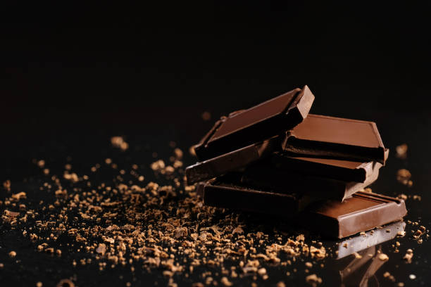 istock Slices of milk chocolate on a black background in the studio. 1225659645
