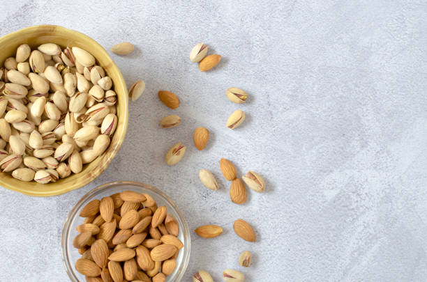 istock Almonds and pistachios on a light background. View from above 1225660523