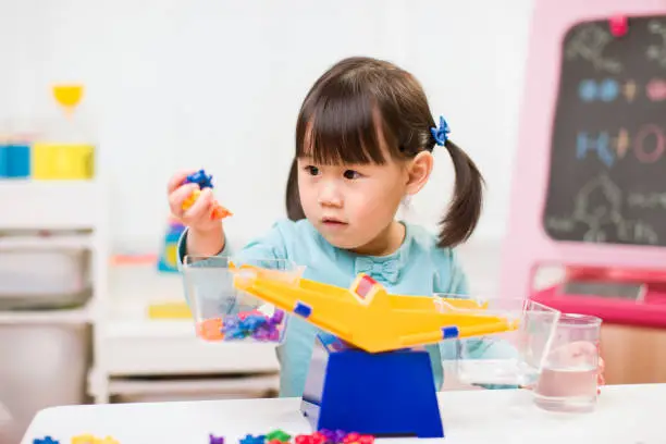 Photo of toddler girl play balance toy for homeschooling