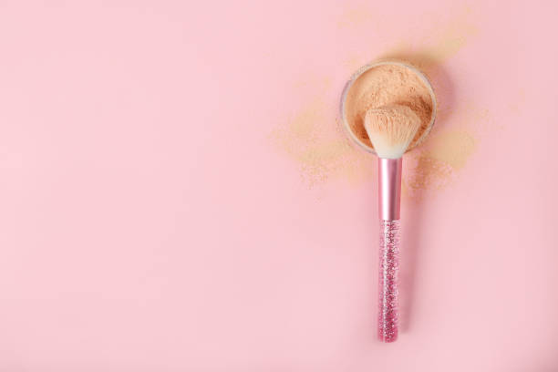 istock Brush and loose powder on a pink background. Place for text 1225664020