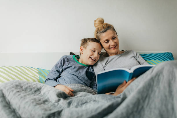 moeder en zoon in slaapkamer brengen wat quality time door - bed fotos stockfoto's en -beelden
